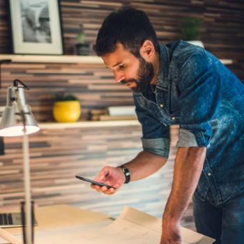 Tools required for remote project management man looking into his phone